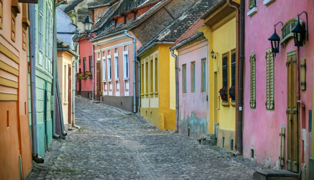 Calle de adoquines rústicos con coloridas casas en el casco antiguo de Sighisoara. Calle de adoquines rústicos con coloridas casas en el casco antiguo de Sighisoara.
