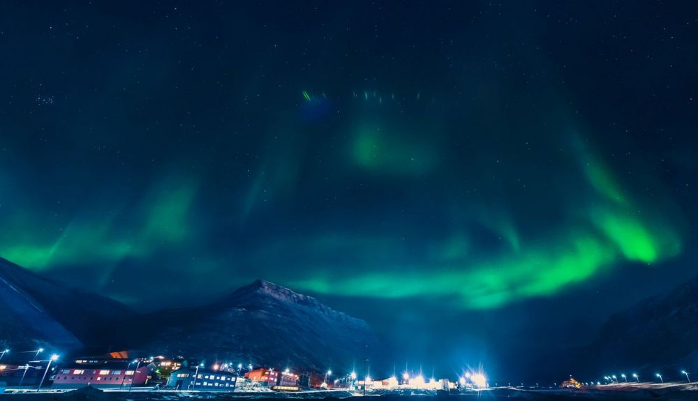 La aurora boreal del Ártico sobre el cielo de la ciudad de Longyearbyen.