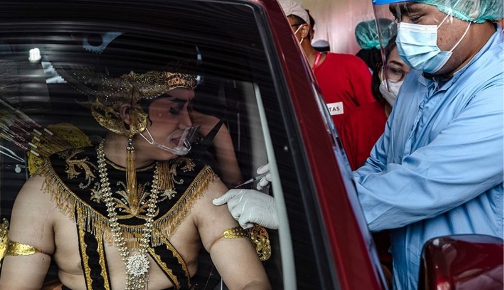 Un hombre con el traje tradicional javanés recibe una dosis de la vacuna Sinovac contra la  Covid 19 en un templo en Yogyakarta, en Indonesia.