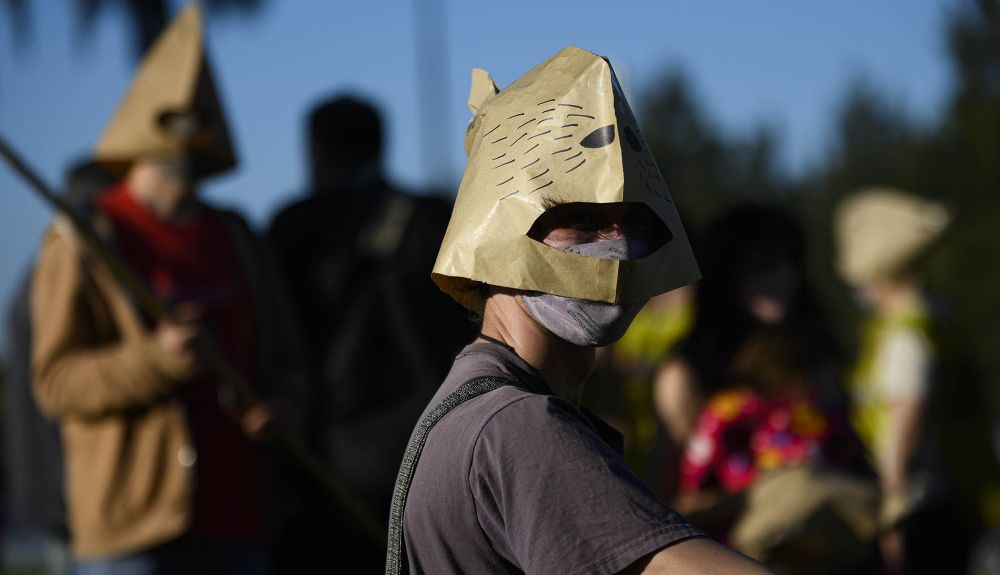 Activistas protestando con cascos de capibaras para que éstos tengan protección.