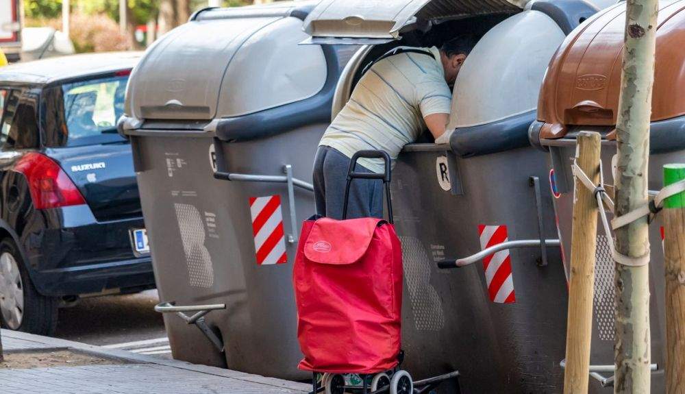 Un hombre rebusca en la basura, durante el estado de alarma.