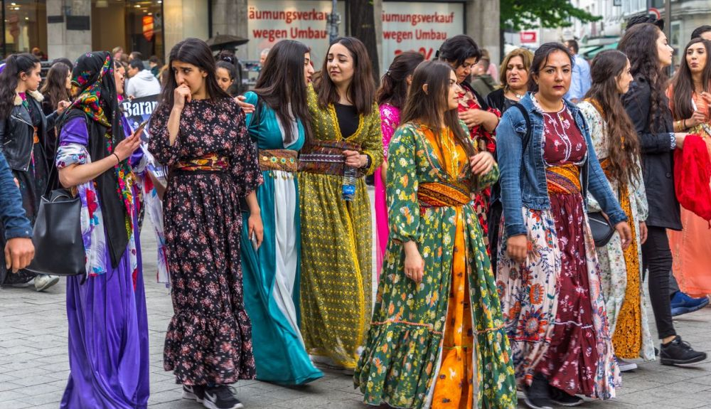 Niñas y mujeres kurdas con vestimenta tradicional en una manifestación en la zona peatonal del centro de Hannover.