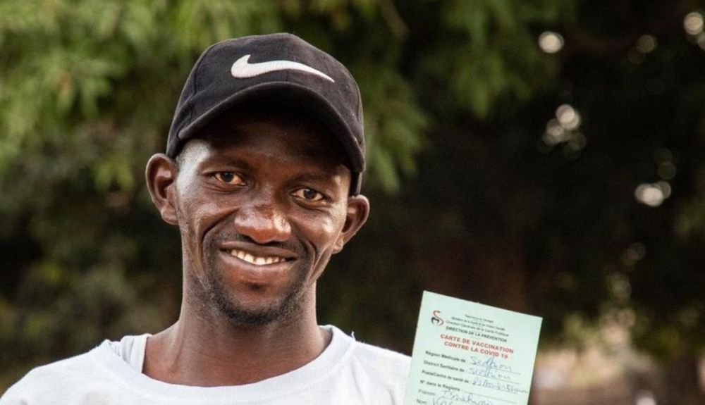 Un hombre senegalés muestra su tarjeta de vacunación de la Covid 19.