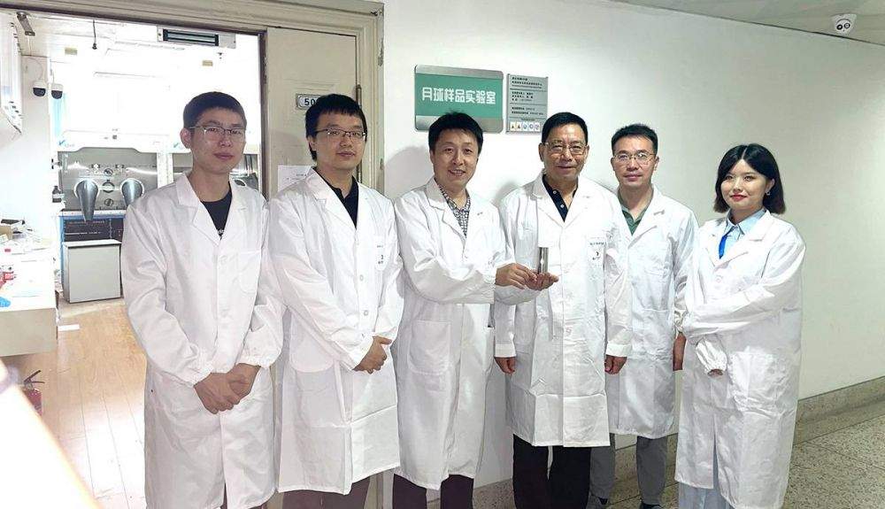 Equipo de investigación de la Universidad de Nanjing, con la muestra de suelo lunar.