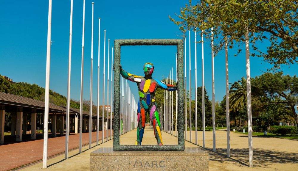 Escultura Marc frente a los 169 postes de bandera de las naciones que enviaron atletas a los Juegos Olímpicos de Verano de 1992 en Barcelona