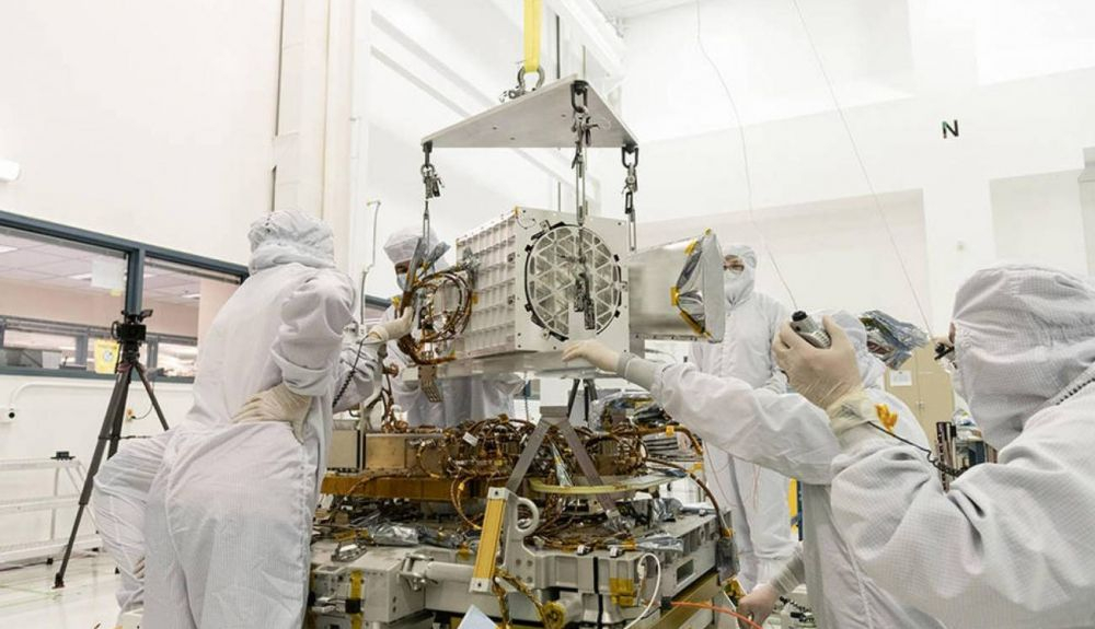 Ingenieros y técnicos del laboratorio JPL ensamblan los componentes de EMIT, incluyendo su telescopio, su espectrómetro de imágenes y su placa base, que contiene sus partes electrónicas. Ingenieros y técnicos del laboratorio JPL ensamblan los componentes de EMIT, incluyendo su telescopio, su espectrómetro de imágenes y su placa base, que contiene sus partes electrónicas.