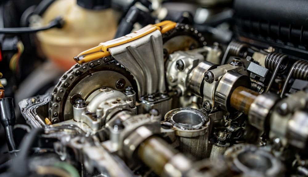 Primer plano de los componentes internos del motor del automóvil, incluidos el árbol de levas y las cadenas