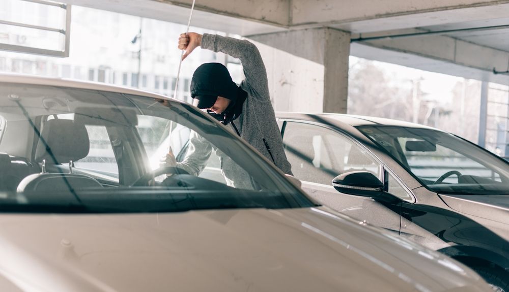Imagen de un ladrón intentando robar un coche de un garaje