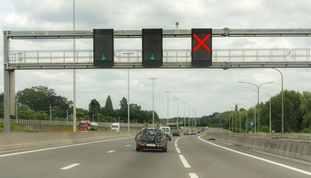 Una señal luminosa con un aspa o una cruz roja indica un cierre temporal de un carril y hay que abandonarlo lo antes posible