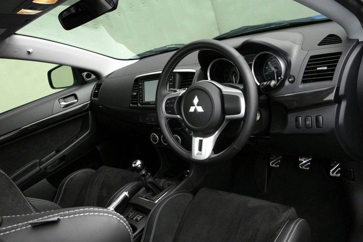 Interior bien acabado con inserciones cromadas en esta versión del Evo X.