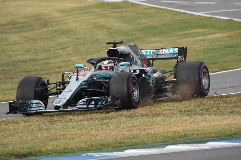 Hamilton cruza por la hierba en la entrada a boxes para volver a la pista