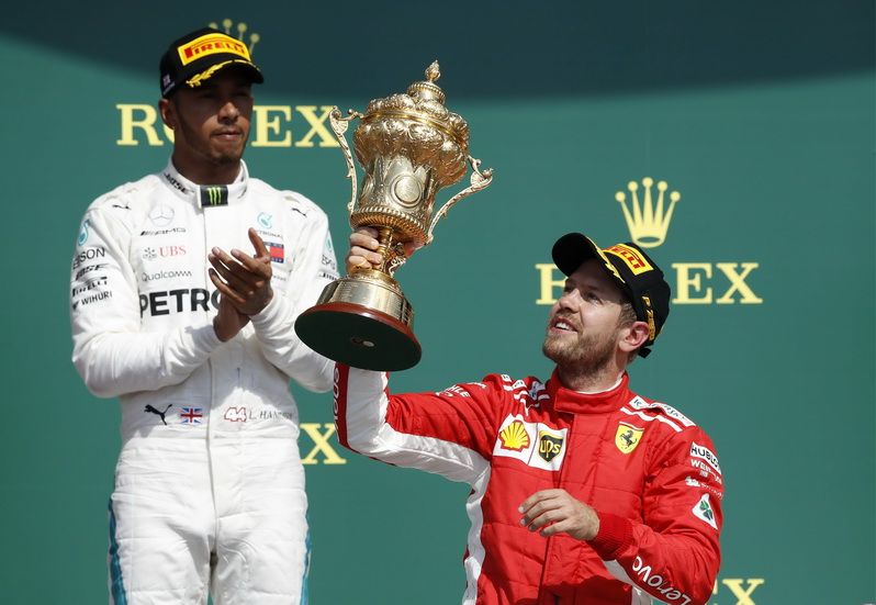 Vettel con el trofeo de la victoria junto a Hamilton