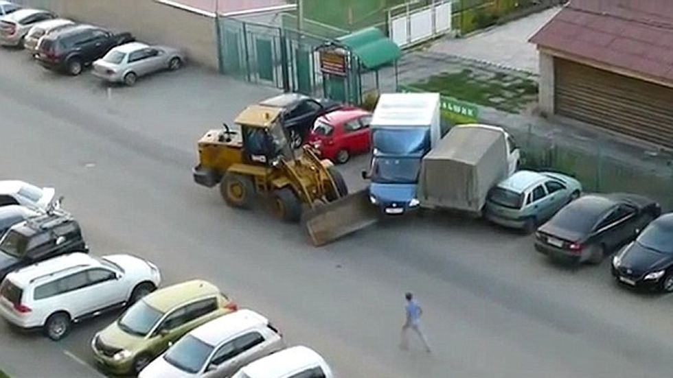 Una excavadora arremete contra varios coches (vídeo)