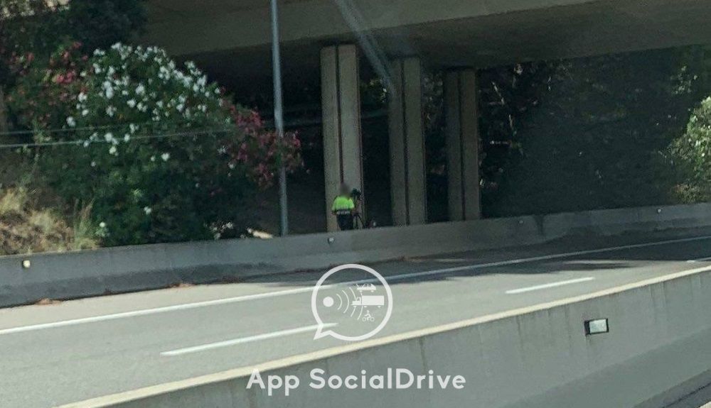 Agente escondido detrás de un puente con pistola láser
