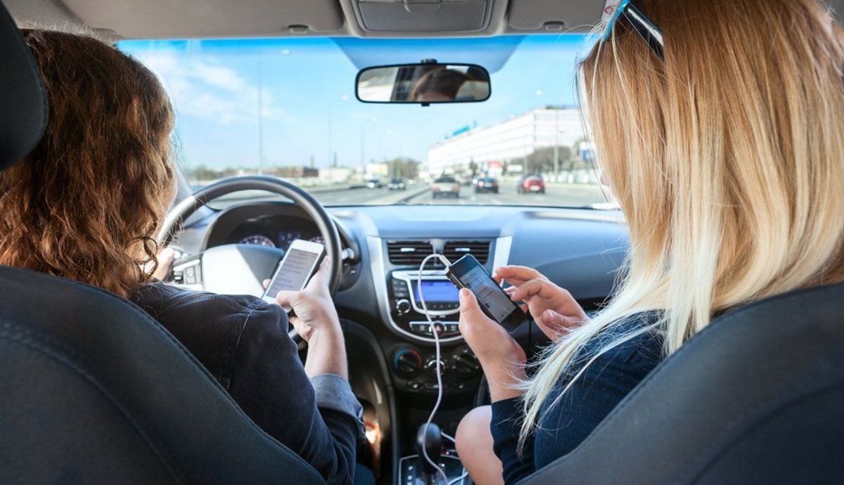 La DGT confirma la multa por manipular ya móviles, navegadores o auriculares en el coche.