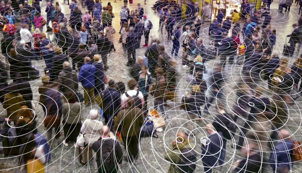 Señales de teléfono celular de radio en una multitud de personas.