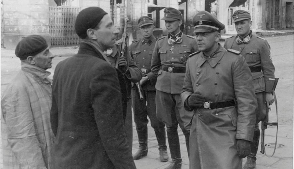 Soldados alemanes interrogando a judíos en el gueto de Varsovia.