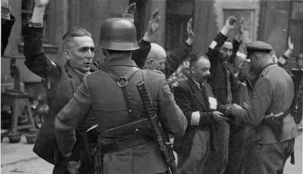 Soldados alemanes deteniendo a judíos en el gueto de Varsovia.