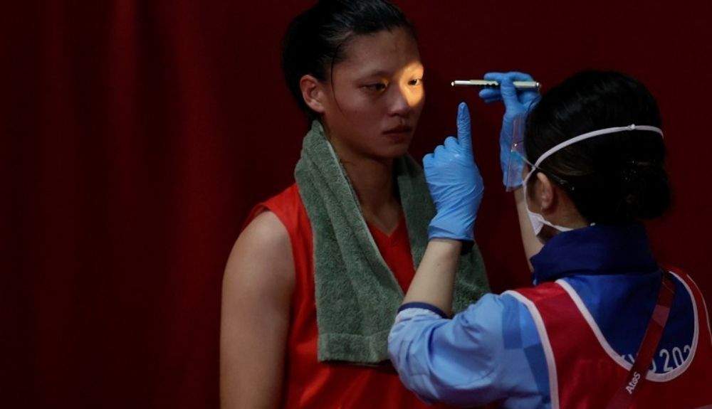 Un médico examina a una atleta por lesiones durante un combate de boxeo en los Juegos Olímpicos de Tokio en julio de 2021