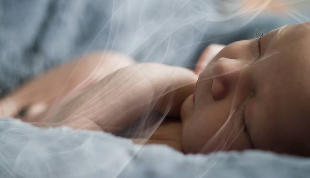 Un bebé respira el humo del tabaco.