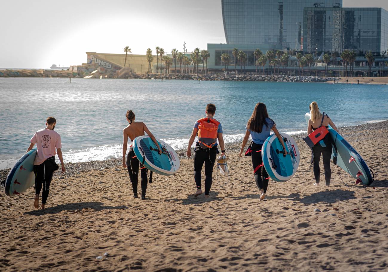 Voluntarios que practican paddle surf en las playas de Barcelona. Foto: Sinc.