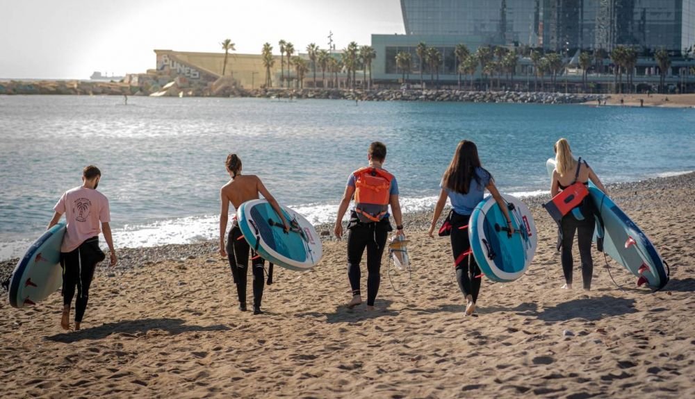Voluntarios que practican paddle surf en las playas de Barcelona. Foto: Sinc.