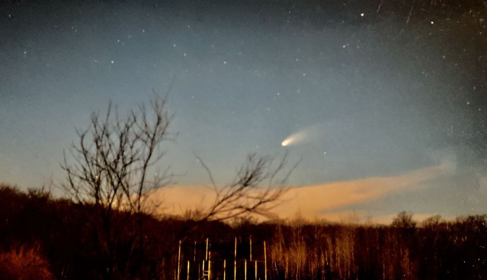 Un momento del paso del cometa Hale Bopp sobre un campo.