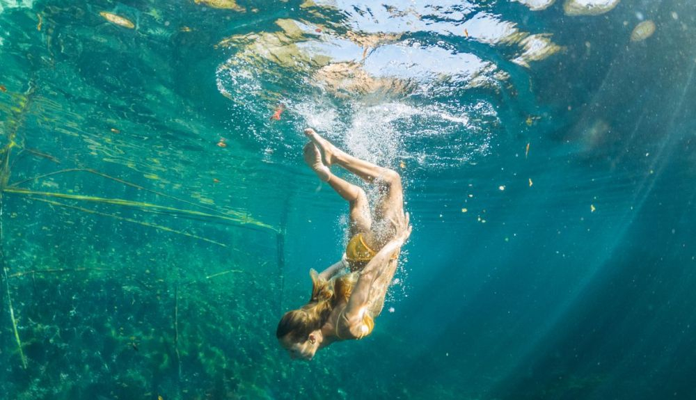 Una mujer, buceando en un cenote en México.