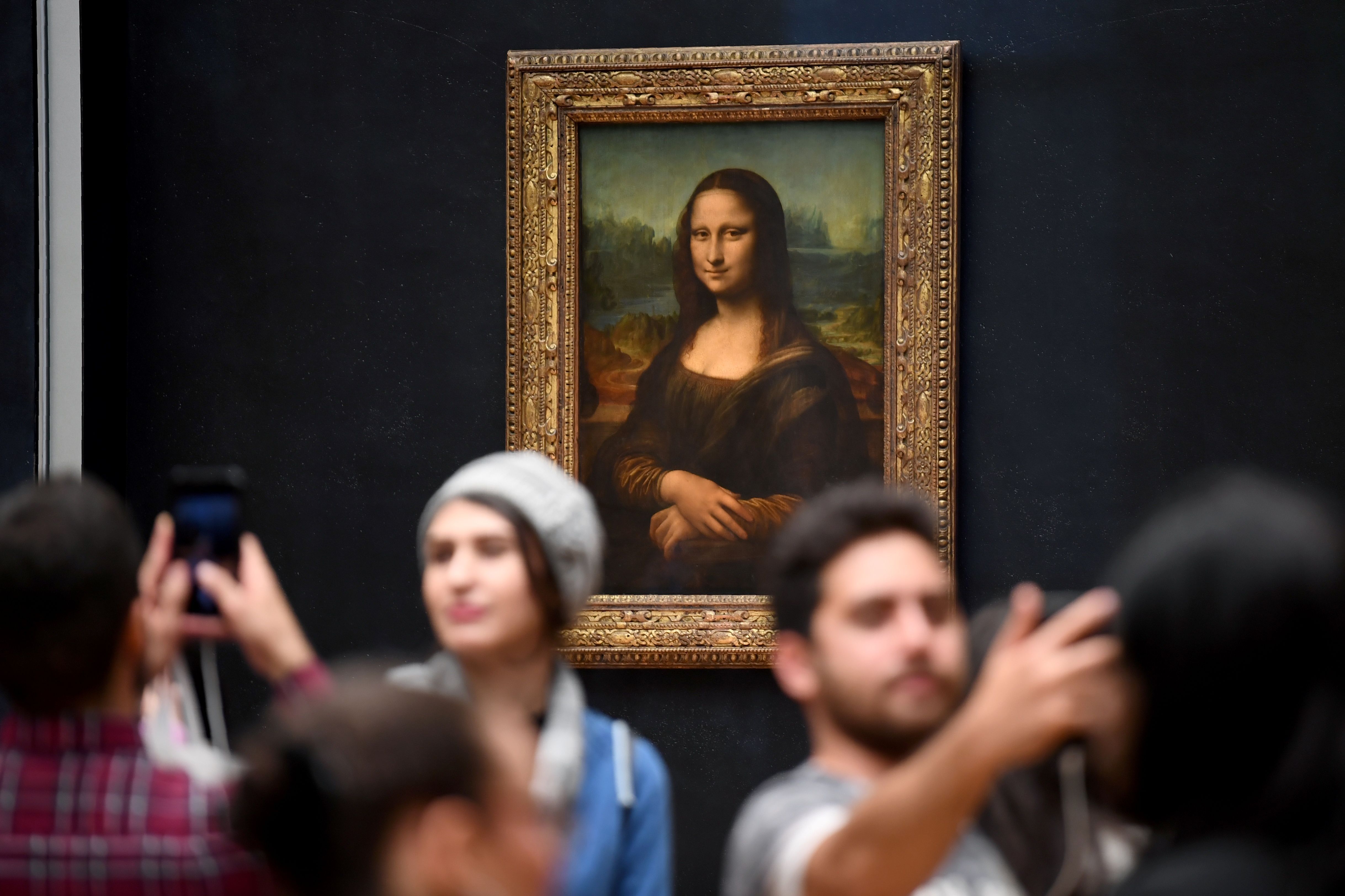 Los visitantes toman fotografías frente a la Mona Lisa en el Museo del Louvre en París.