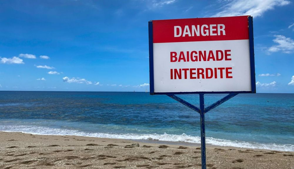 Señal de peligro. La natación está prohibida debido a los tiburones en lsla Reunión. Señal de peligro. La natación está prohibida debido a los tiburones en lsla Reunión.